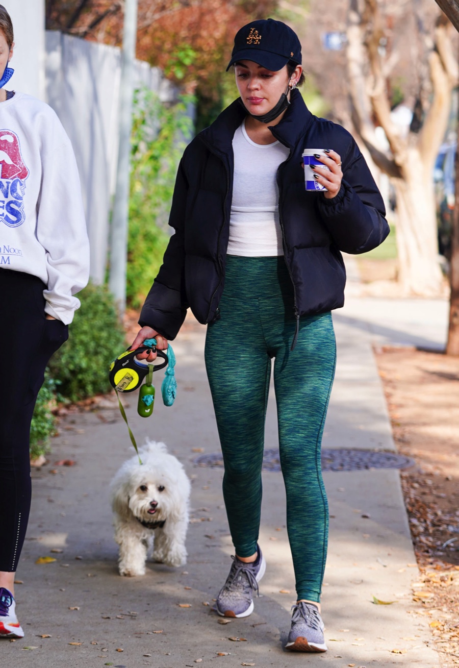 Lucy Hale wears a red 'LA' hat with denim jacket and black leggings during  a coffee